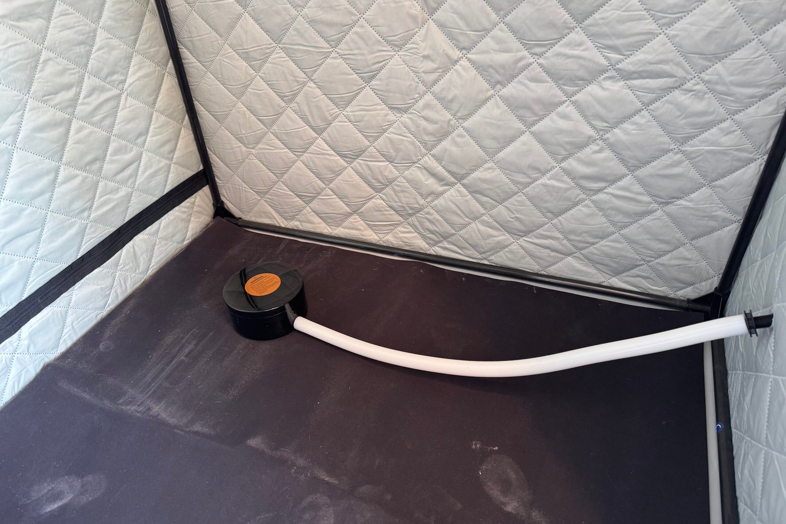 The steam output box of the saunabox smartsteam kit pro positioned toward the back corner of the sweat mat