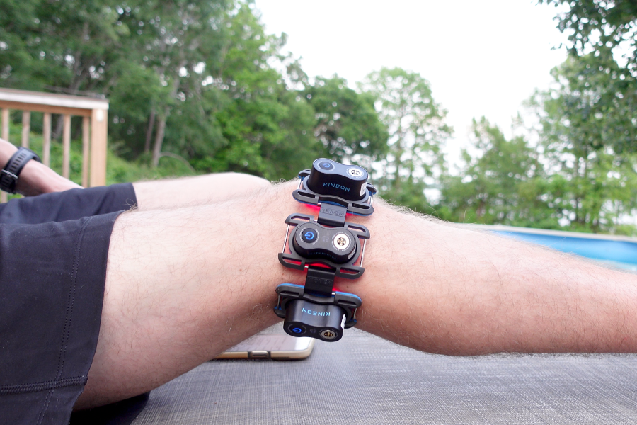 Three Kineon Move+ modules strapped across a knee while lying down outdoors with red light active