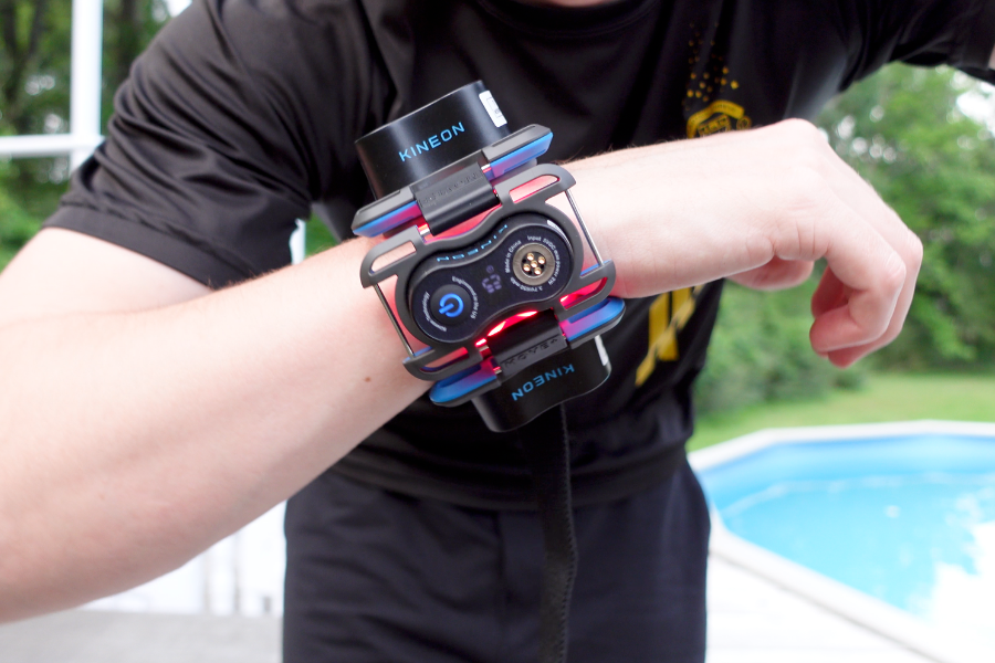 Kineon Move+ red light therapy device strapped to Bennett Carby's wrist outdoors